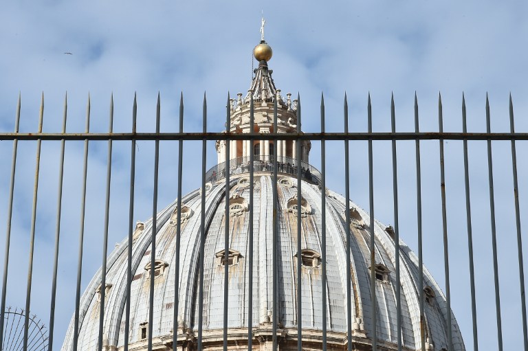 A picture shows the cuppola of St Peter's basilica behind a fence on March 14, 2016 in Vatican during the "Vatileaks" trial of two journalists and three former Vatican officials.  A controversial Vatican trial of journalists and alleged whistleblowers resumes today, in the latest instalment of an image-bruising legal saga. The spicy courtroom drama has already served up claims of sexually charged scheming, blackmail and computer hacking behind the fortified walls of the secretive city state.  / AFP / ALBERTO PIZZOLI