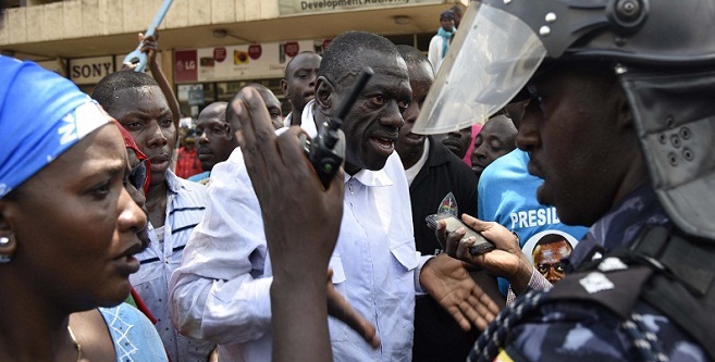 Uganda Anti-riot police officers stop a Forum for Democratic Change (FDC)l challenger Kizza Besigye (C) during the campaigns. Court has stopped his defiance campaign earlier and today charged with treason.