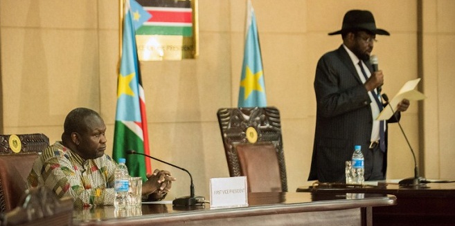 President Salva Kiir (R) delivers a statement as former rebel leader and new vice-president Riek Machar listens during a ceremony at the Presidential House in Juba after Machar was sworn in as new vice-president, following hus arrival at Juba international airport on April 26, 2016. The return of rebel leader Riek Machar to Juba must pave the way for a genuine transition to end more than two years of brutal civil war in South Sudan, the UN peacekeeping chief said on April 26.  / AFP PHOTO / Charles Lomodong