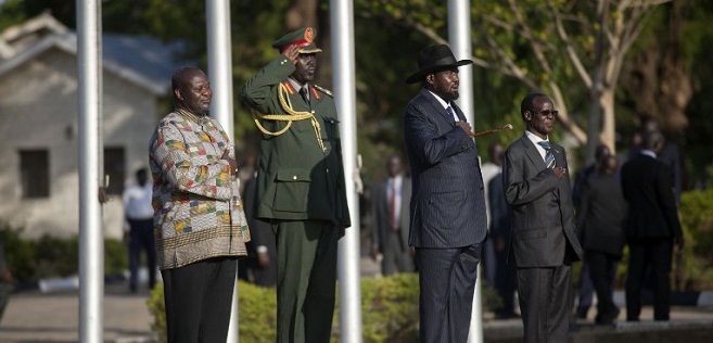 Former rebel leader and new vice-president Riek Machar (Rear C) and President Salva Kiir (2nd R) listen to the national anthem at the Presidential House in Juba after Machar was sworn in as new vice-president, after Machar landed at Juba international airport on April 26, 2016. The return of rebel leader Riek Machar to Juba must pave the way for a genuine transition to end more than two years of brutal civil war in South Sudan, the UN peacekeeping chief said on April 26. / AFP PHOTO / Albert Gonzalez Farran