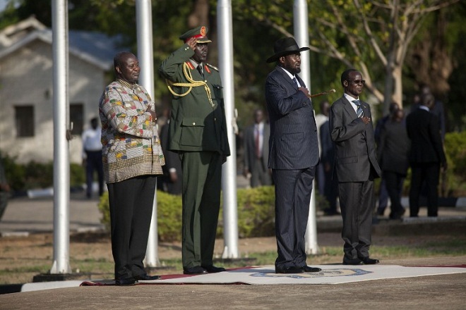 Former rebel leader and new vice-president Riek Machar (Rear C) and President Salva Kiir (2nd R) listen to the national anthem at the Presidential House in Juba after Machar was sworn in as new vice-president, after Machar landed at Juba international airport on April 26, 2016. The return of rebel leader Riek Machar to Juba must pave the way for a genuine transition to end more than two years of brutal civil war in South Sudan, the UN peacekeeping chief said on April 26. / AFP PHOTO / Albert Gonzalez Farran