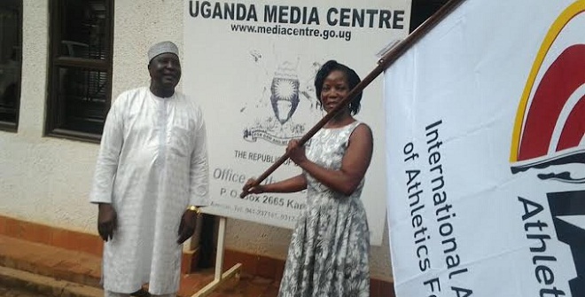 KCCA ED Musisi waves the IAAF flag at yesterday's press conference attended by IAAF and Uganda athletics officials. PHOTO BY CHARLOTTE NINSIIMA