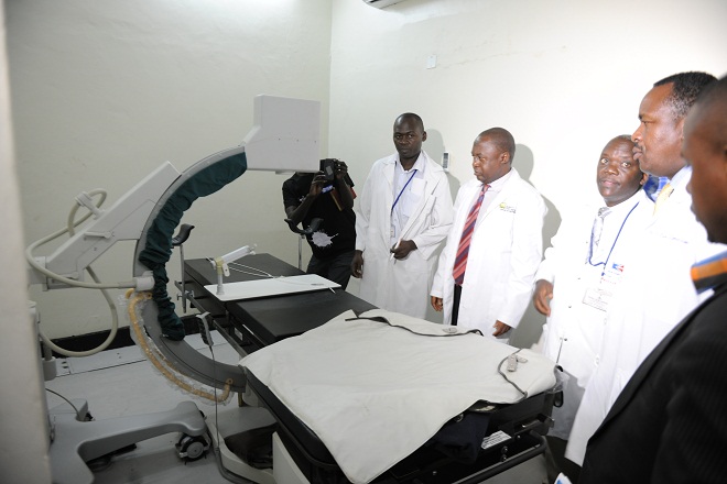 Minister Elioda Tumwesigye shows journalists a brachytherapy machine at the radiology unit. unlike the Cobalt machine, this provides internal radiation.