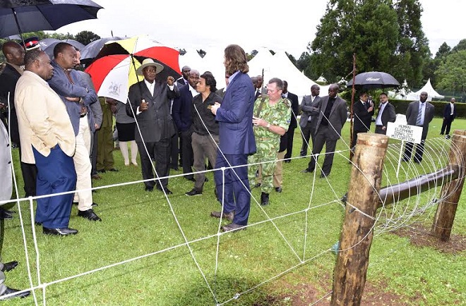 Museveni, Kenyatta and Bongo being shown an electric fence used to control movement of elephants.