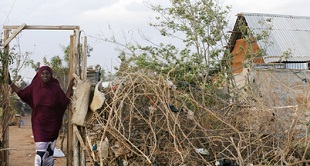 A displaced Somali woman stands at the entrance to her temporary home at the Ifo 2 Refugee Camp in Dadaab, Kenya,. UN PHOTO