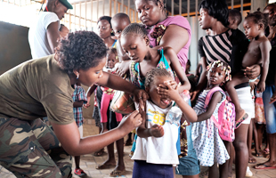 Angolan military administers a yellow fever vaccine to a child at 'Quilometro 30' market, Luanda, Angola, 16 February 2016. This market in the Angolan capital was considered the center of the yellow fever outbreak killing 51 people out of 240 cases since December of 2015.  WHO PHOTO
