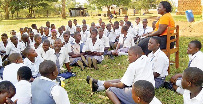 A teacher talks to girls under the Straight Talk programme