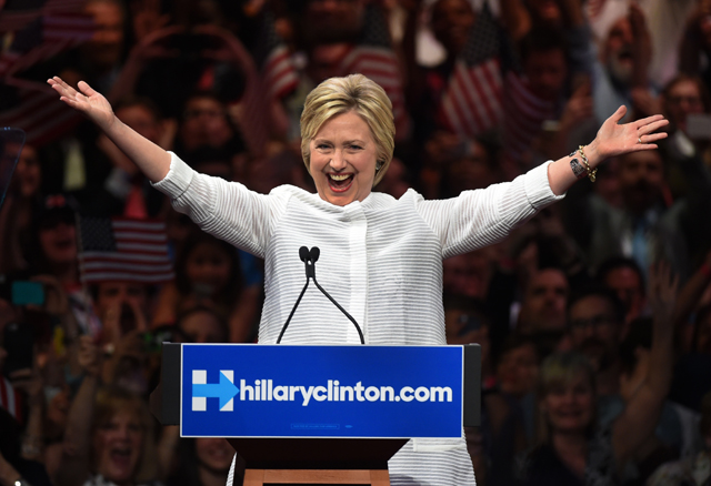 Democratic presidential candidate Hillary Clinton celebrates on stage during her primary night event at the Duggal Greenhouse, Brooklyn Navy Yard, June 7, 2016 in New York. Hillary Clinton hailed a historical "milestone" for women as she claimed victory over rival Bernie Sanders in the Democratic White House nomination race. "Thanks to you, we've reached a milestone," she told cheering supporters at a rally in New York. "The first time in our nation's history that a woman will be a major party's nominee." / AFP PHOTO / TIMOTHY A. CLARY