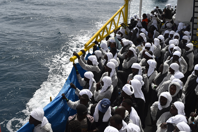 Migrants wait aboard rescue ship "Aquarius" as they arrive in the port of Cagliari, Sardinia, on May 26, 2016, two days after being rescued near the Libyan coasts. The Aquarius is a former North Atlantic fisheries protection ship now used by humanitarians SOS Mediterranee and Medecins Sans Frontieres (Doctors without Borders) which patrols to rescue migrants and refugees trying to reach Europe crossing the Mediterranean sea aboard rubber boats or old fishing boat.  / AFP PHOTO / GABRIEL BOUYS