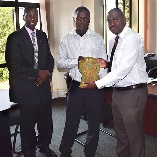 FILE PHOTO UWA: Ssegamwenge Henry Technical Director of Nile Comrades Group of Companies Hands over an UWA Logo Bronze Plaque to Dr. Andrew Seguya in presence of Mr. Stephen Masaba the UWA Business Development Manager