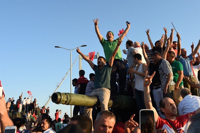  People react after taking over military position on the Bosphorus bridge in Istanbul, on July 16, 2016 