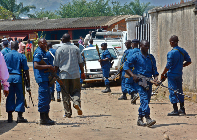 Security personnel block the area close to where the body of Col. (Rtd) Lucien Rufyiri lies on May 25, 2015 in the Burundian capital, Bujumbura after he was gunned down by unidentified gunmen as he arrived at his residence. The Tutsi colonel who has been retired for several years was killed outside his home in a rebellious district of Bujumbura "by armed criminals", according to a source within the family. "Colonel Lucien Rufyiri has been murdered this morning in front of his house and a son who was with him was injured," he told AFP a family member, who requested anonymity. / AFP PHOTO / ONESPHORE NIBIGIRA