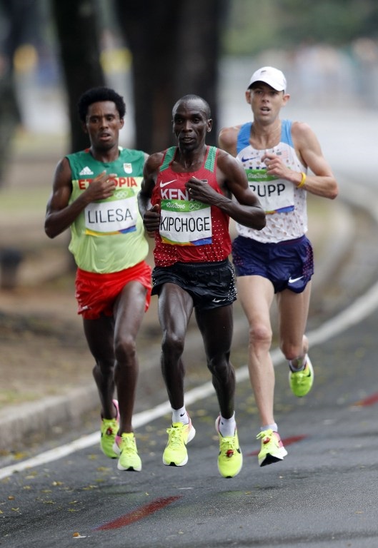 (FromL) Ethiopia's Feyisa Lilesa, Kenya's Eliud Kipchoge and USA's Galen Rupp run during the Men's Marathon athletics event at the Rio 2016 Olympic Games in Rio de Janeiro on August 21, 2016.   / AFP PHOTO / Adrian DENNIS
