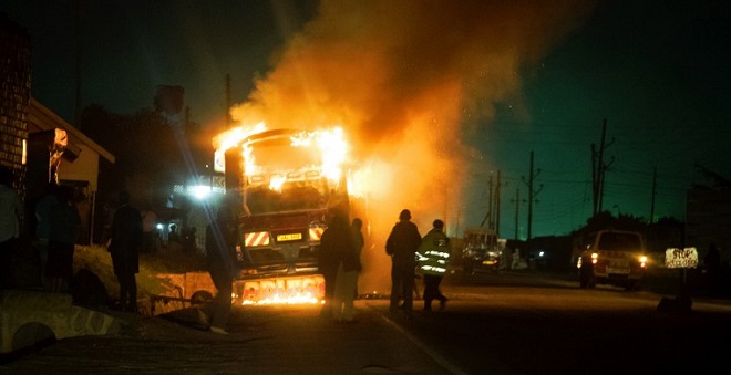 TO GO WITH AFP STORY BY MICHAEL O'HAGAN A photo taken on May 12, 2015 shows a bus on fire on the infamous Kampala-Masaka road in Buwama village. The passengers luckily had time to get out of the vehicle but they lost all their belongings. About 200 people have died on the road alone since January 2016. More people have died on the 130-km Kampala-Masaka Highway in 2016 than in the whole of an average year on Yungus Road, the notorious Bolivian mountain pass known as Death Road. An average 200 to 300 people die there each year. The road provides essential access from the Kenyan coast thourgh Uganda to Democratic Republic of Congo, Rwanda and Burundi. / AFP PHOTO / MICHELE SIBILONI