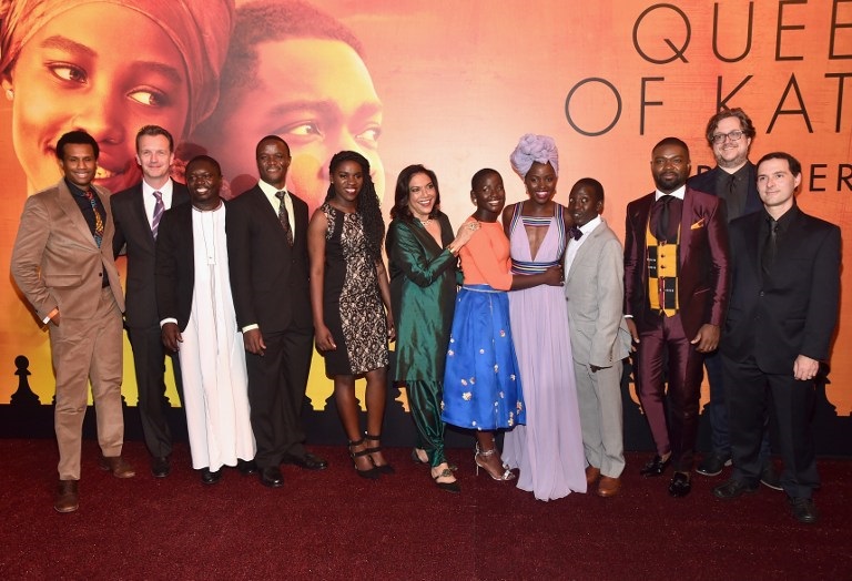 HOLLYWOOD, CA - SEPTEMBER 20: (L-R) Executive Vice President of Production, The Walt Disney Studios, Tendo Nagenda, President of Walt Disney Studios Motion Picture Production, Sean Bailey, chaperone Mark Mugwana, Chess Coach and Director of Sports Outreach in Uganda, Robert Katende, Ugandan national chess champion Phiona Mutesi, Director Mira Nair, actors Madina Nalwanga, Lupita Nyong'o, Martin Kabanza and David Oyelowo, screenwriter William Wheeler and composer Alex Heffes arrive at the U.S. premiere of Disney?s ?Queen of Katwe? at the El Capitan Theatre in Hollywood. The film, starring David Oyelowo, Oscar winner Lupita Nyong?o and newcomer Madina Nalwanga, is directed by Mira Nair and opens in U.S. theaters in limited release on September 23, expanding wide September 30, 2016. On September 20, 2016 in Hollywood, California.   Alberto E. Rodriguez/Getty Images for Disney/AFP