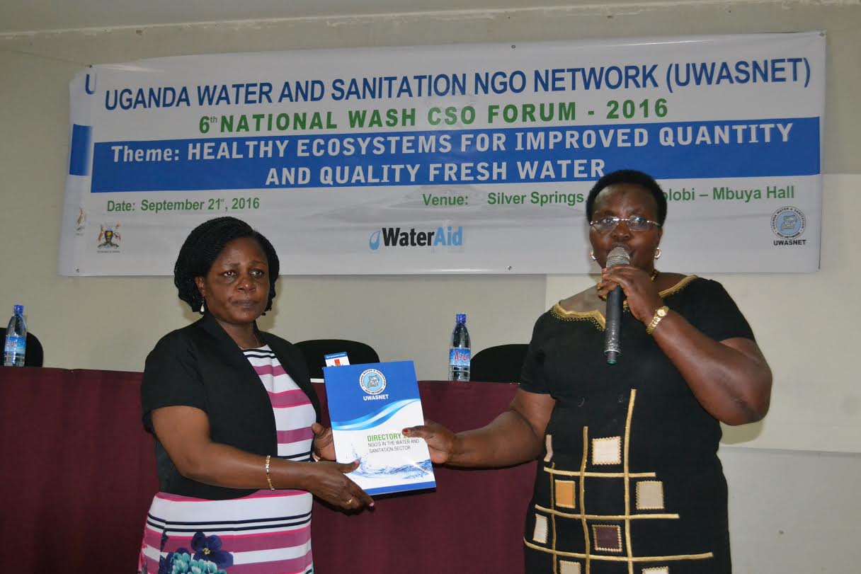 Minister Kitutu receives the 2016 NGO Sector Performance Report from the UWASNET Executive Director, Doreen Kabasindi Wandera