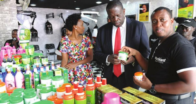 Minister of State for Trade, Michael Werikhe Kafabusa, (M) checks out some of the Radiant products at the 24th UMA Uganda International Trade Fair on Oct. 5. Looking on is the brand ambassador Barbie Kyagulanyi, (L) and Ibrahim Karemera,(R) the Radiant PR manager. INDEPENDENT/JIMMY