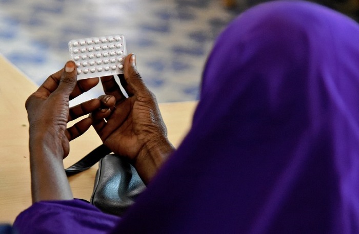 A female religious leader looks at contraceptive pills during a course at the local maternity facility on what Islam allows and does not allow in terms of family planning, and on the benefits of family planning in Wajir town on September 26, 2016. Swaddled in colourful hijabs the women exchange puzzled looks and suppress embarrassed giggles. "You're sure it's halal?" asks one, peering at a collection of birth control pills, condoms and IUDs. / AFP PHOTO / NICOLAS DELAUNAY