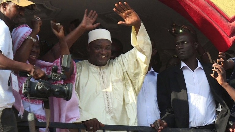 This video grab taken from footage shot by AFPTV shows The Gambia's President-elect Adama Barrow (C) gesturing to the crowd in Kololi on December 2, 2016 following his victory in the polls.  The Gambia's President-elect Adama Barrow was to hold talks with his coalition to plot his transition to power, following a shock election victory that ended the 22-year rule of Yahya Jammeh. The scenes of jubilation on the streets after the results were released gave way to a calm but buoyant mood in the capital Banjul as horsetrading got under way behind closed doors.  / AFP PHOTO / AFPTV / Joe Sinclair
